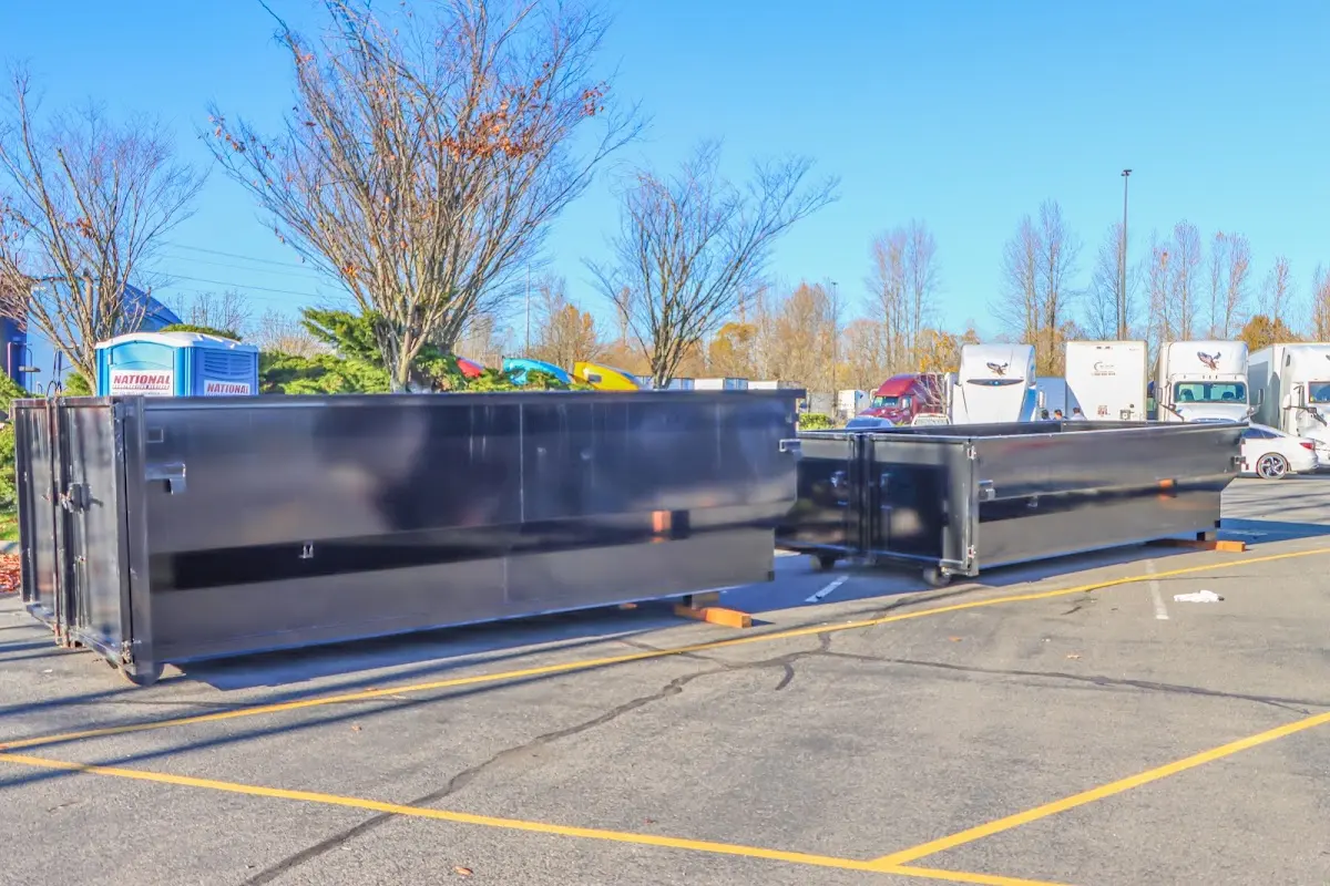 Professional dumpster rental service with roll-off container on residential driveway in Concord